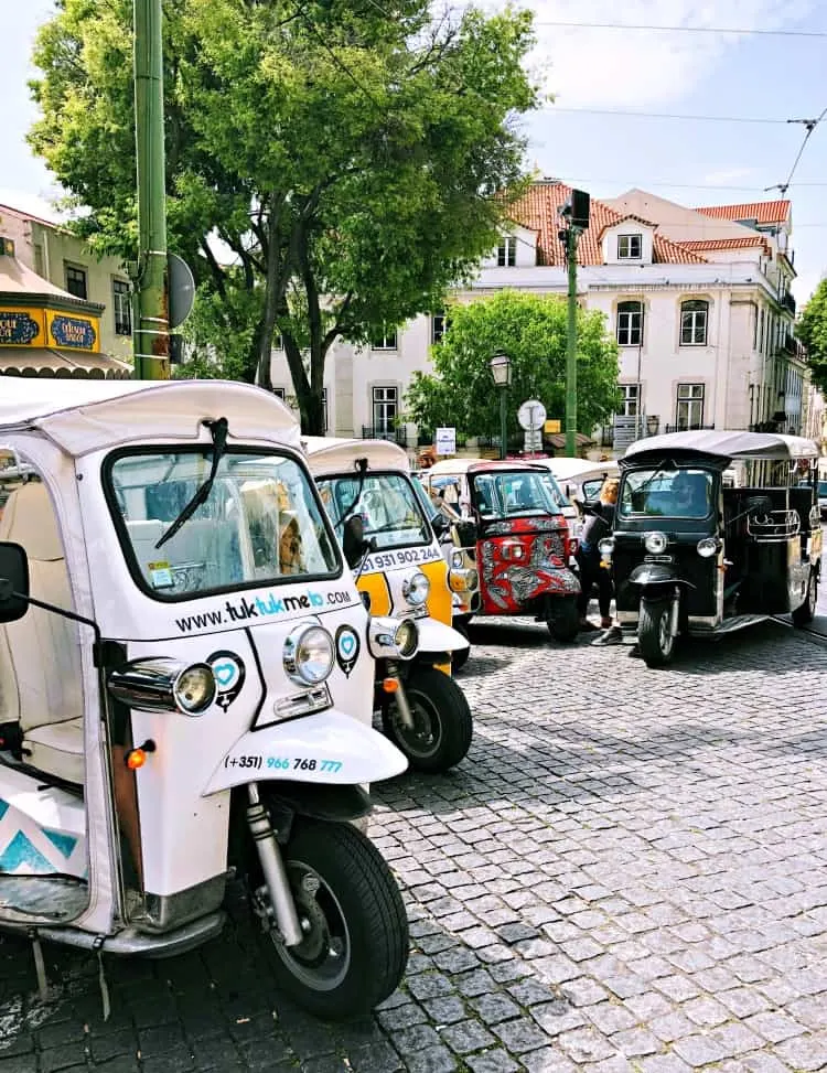 tuk tuks on a street in Lisbon Portugal