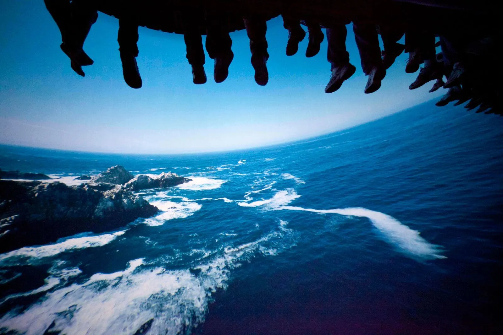 feet hanging in front of screen with ocean waves on soarin over california at disneyland