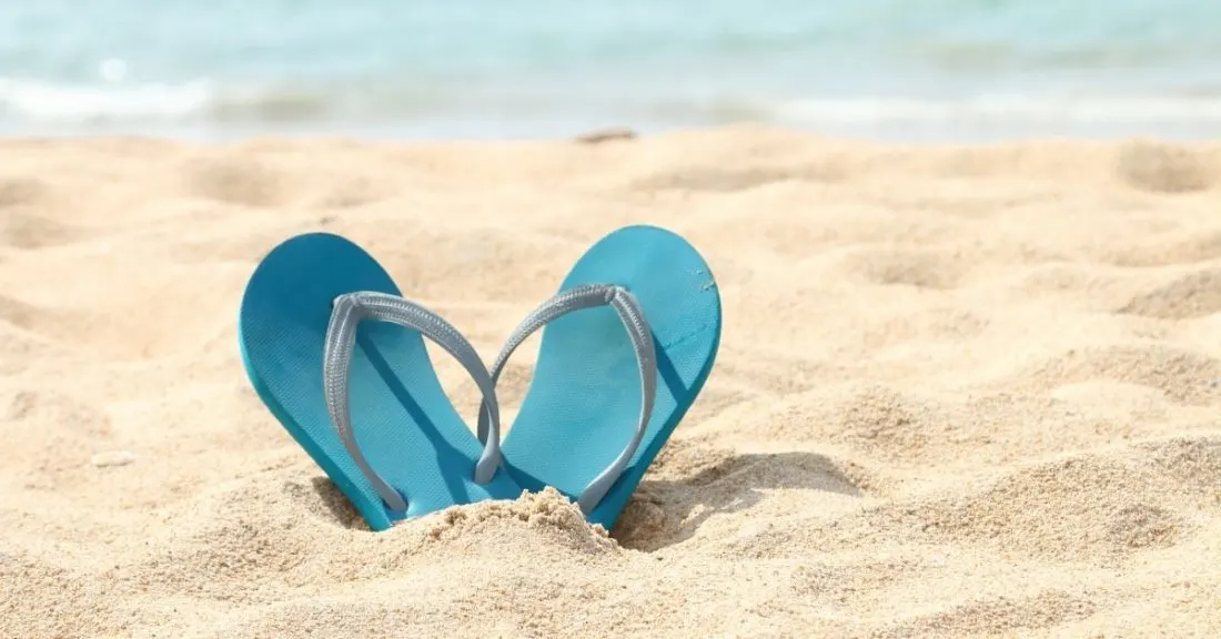 flip flops in the sand. photo credit canva