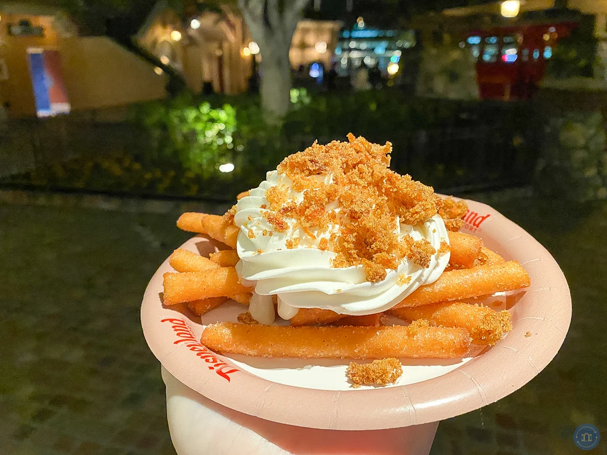 carrot cake funnel fries with cream cheese frosting being held