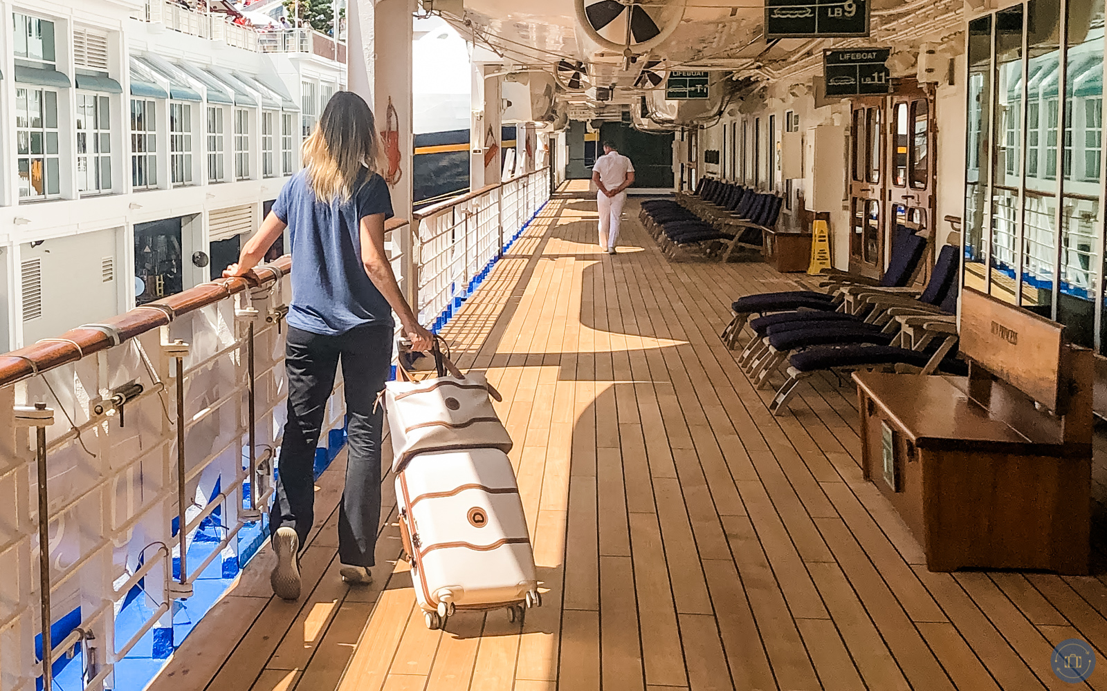 woman with suitcases walking on cruise desk