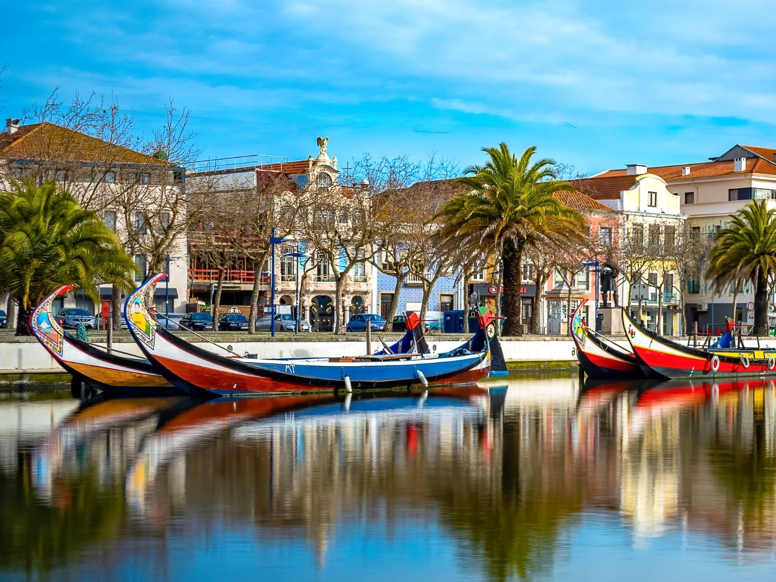 view from river of colorful boats on via of aveiro portugal