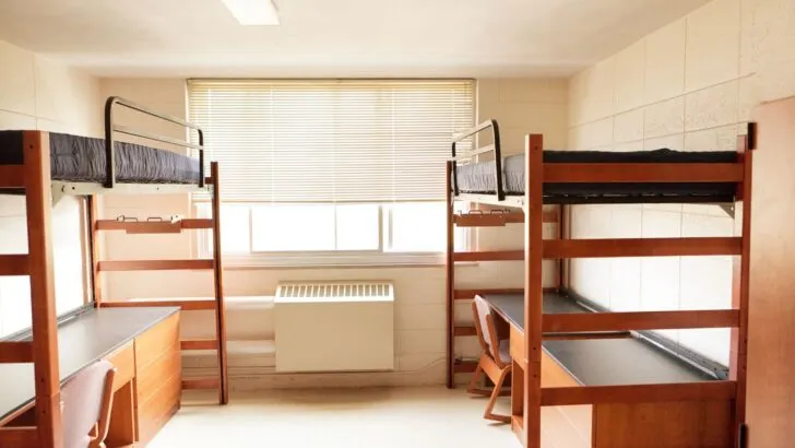 college dorm room with loft beds and desks underneath