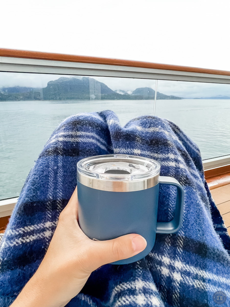 enjoying alaska from holland america cruise ship balcony holding cup of coffee in my hand