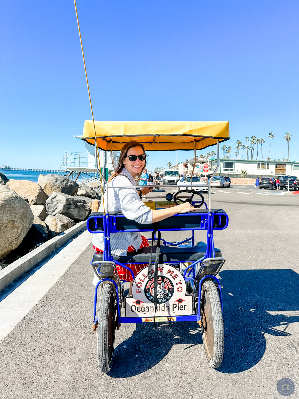 girl posing in pedal surrey on the strand in oceanside ca near oceanside pier