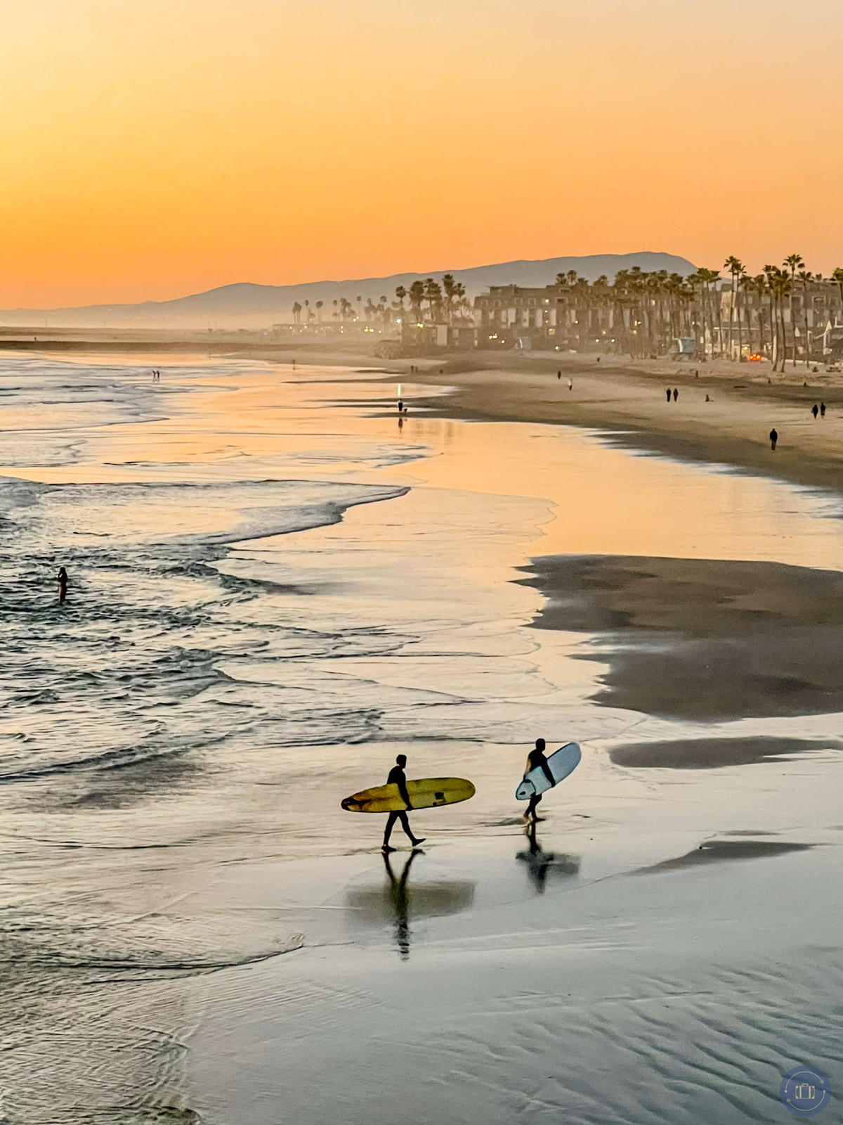 surfers on the beach at sunset in oceanside california