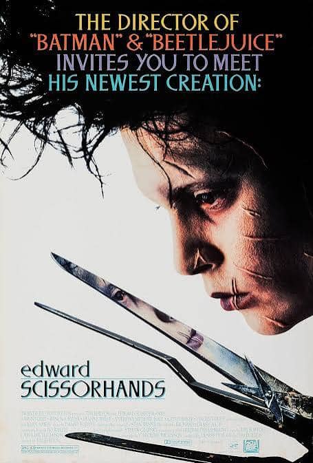 Johnny Depp as Edward Scissorhands looking down sadly at a pair of large scissor blades for Tim Burton's classic gothic family film