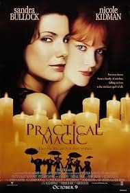 Sandra Bullock and Nicole Kidman posing closely together behind a cluster of glowing pillar candles for the classic witch movie Practical Magic