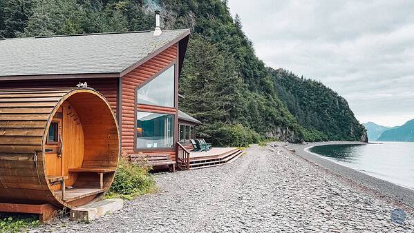 A wooden sauna sitting on the shore next Kenai Fjords Wilderness Lodge on Fox Island in Alaska.