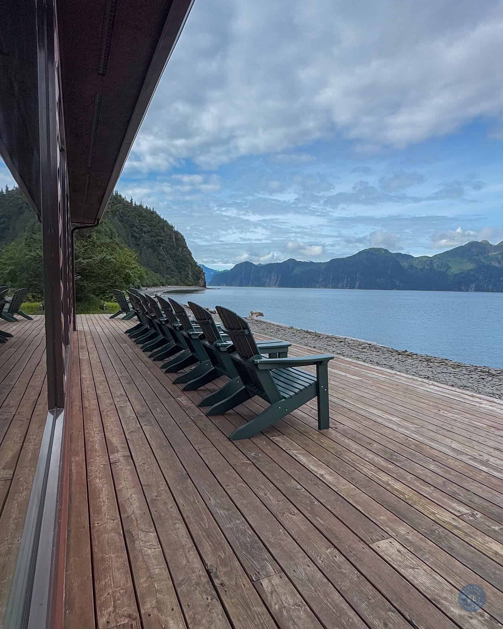 A wooden deck with chairs and a view of the ocean in Alaska