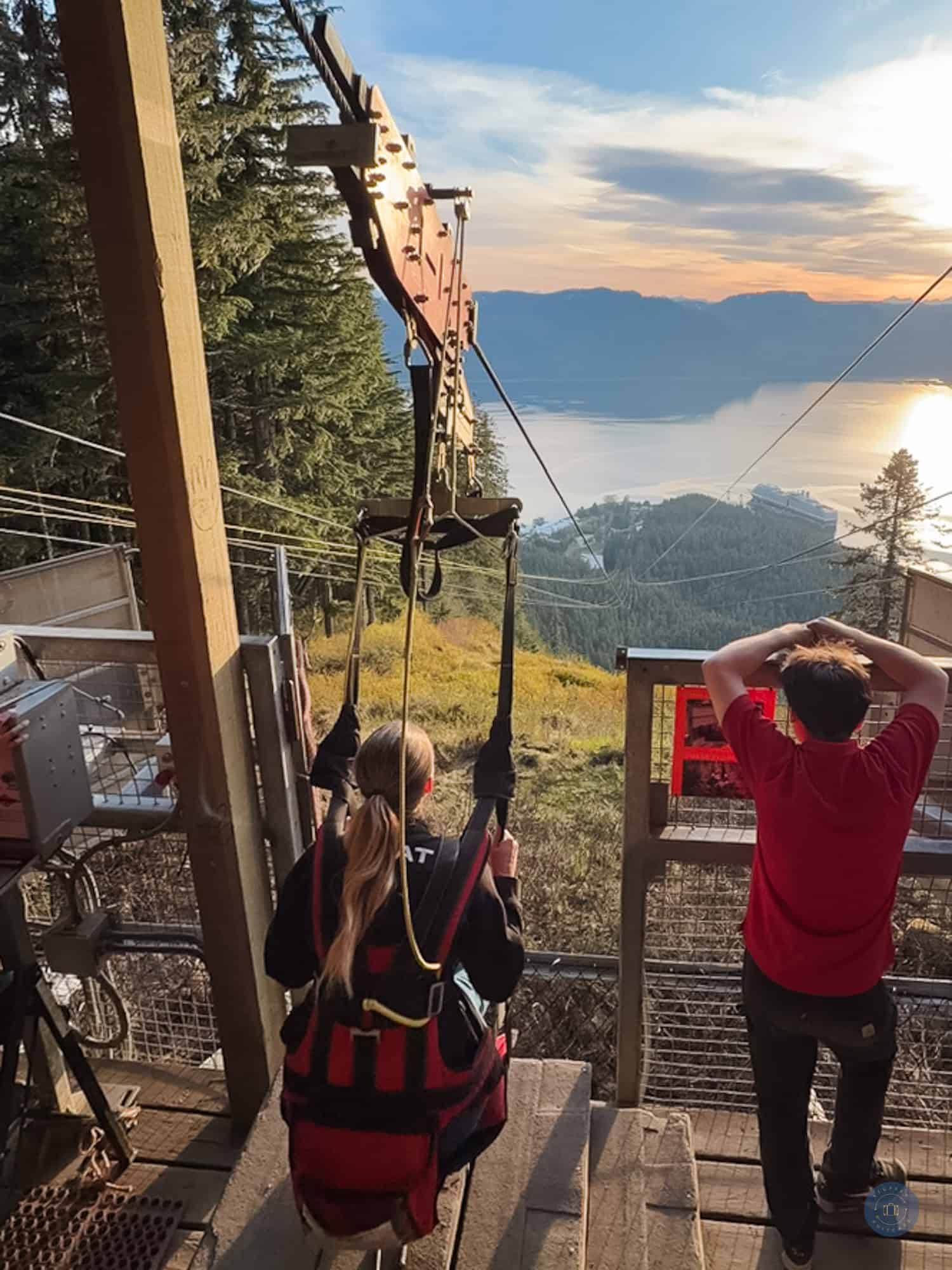person in chair waiting to be released on ziprider zipline at sunset in icy strait point alaska