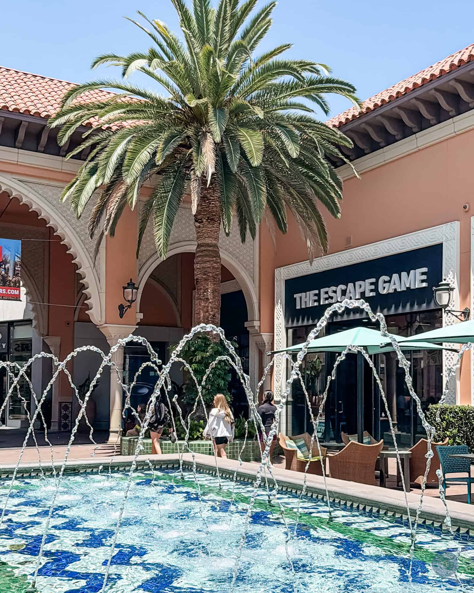 Palm tree and The Escape Game store with fountain in Irvine, California at Irvine Spectrum Center mall