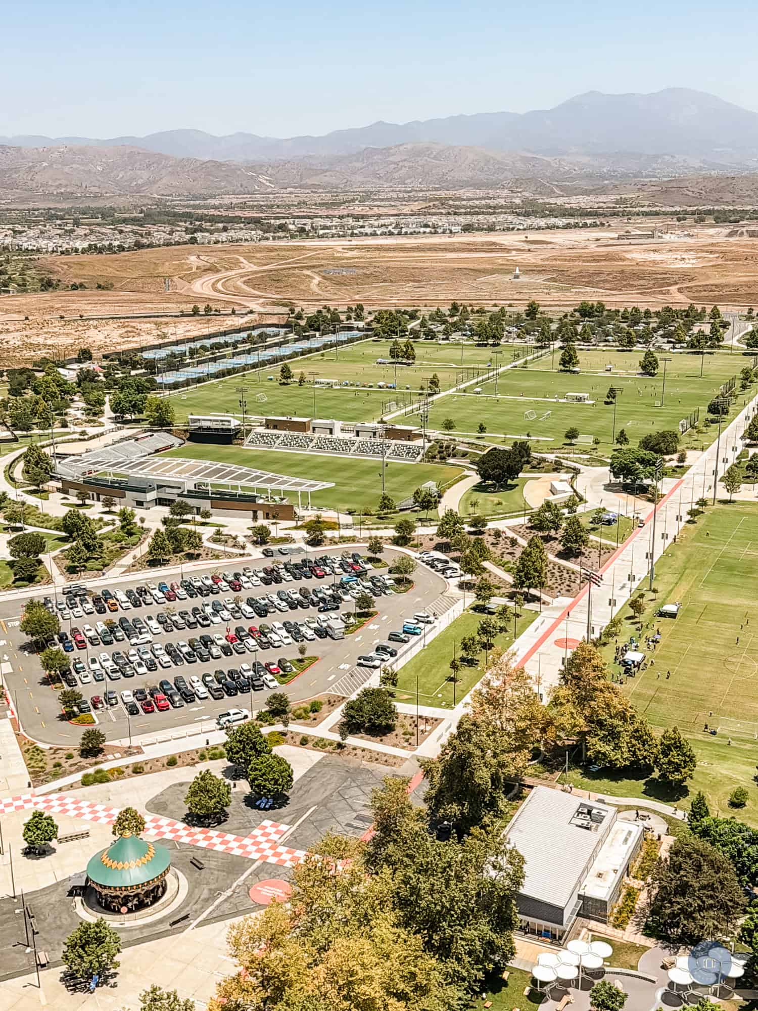 Aerial view from Great Park Balloon of sports fields and park in Irvine with mountains in background.